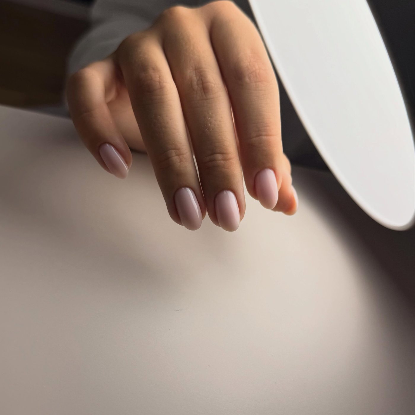 Hand met nagels in een zachte mauve tint